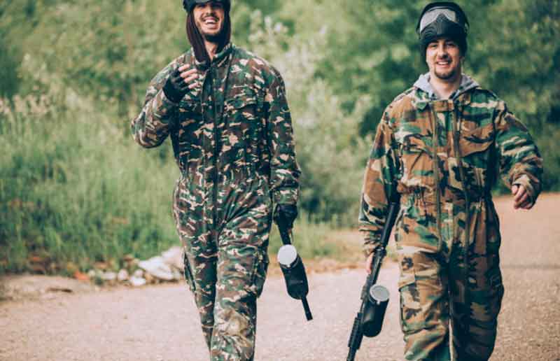 Friends laughing in paintball outfits