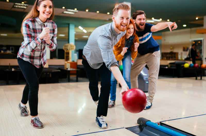 Guy bowling with his friends