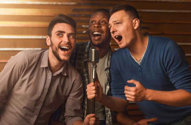 Guy friends singing karaoke