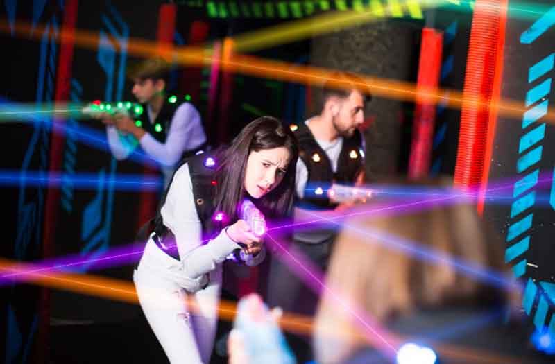 Laser tag teenagers pointing at target