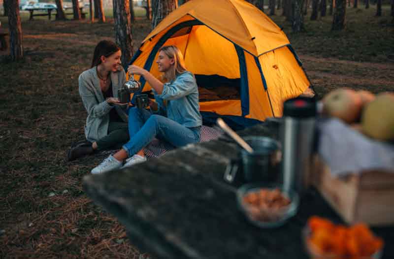 Girlfriends camping outdoors