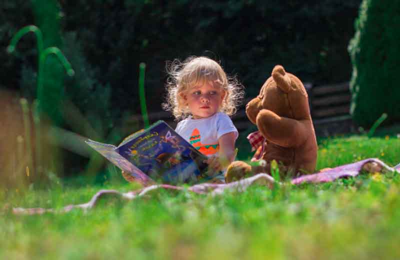 3-year-old reading a book at the zoo