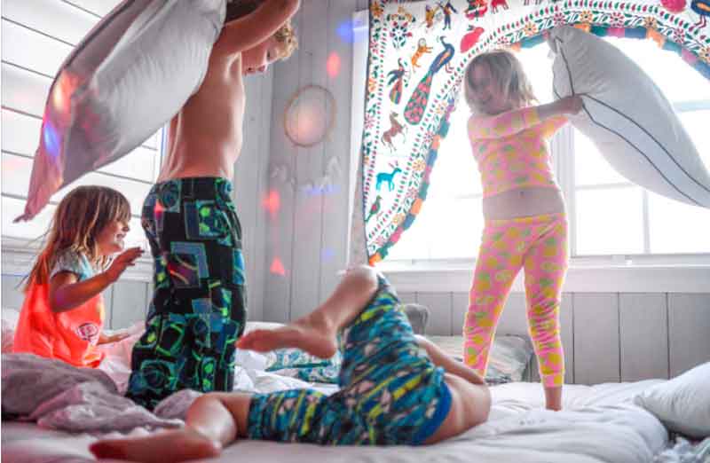 3-year-olds jumping on a bed