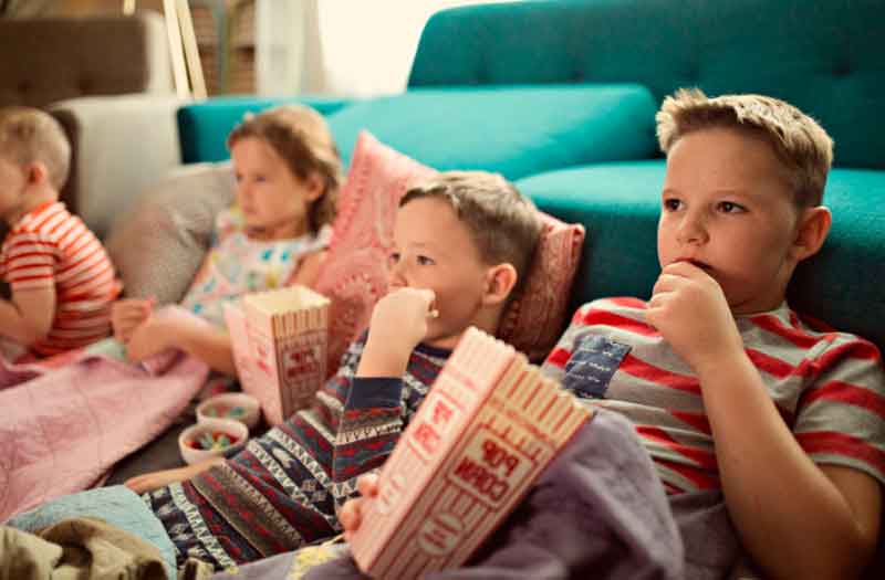 6-year-olds watching movies and eating popcorn