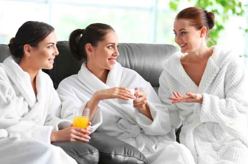 Girls drink orange juice at the spa