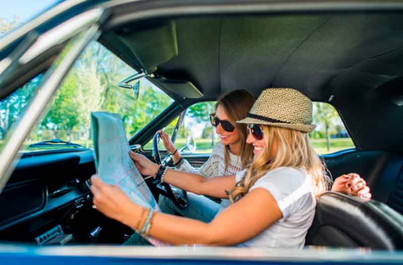 Girls travel in a vintage car