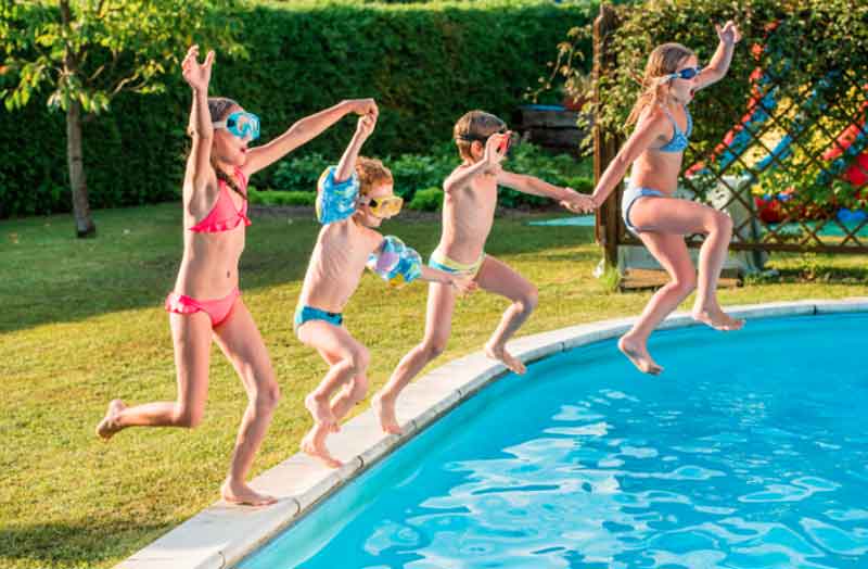 Kids jumping into a pool