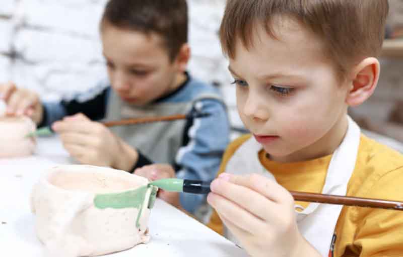 Kids painting pottery