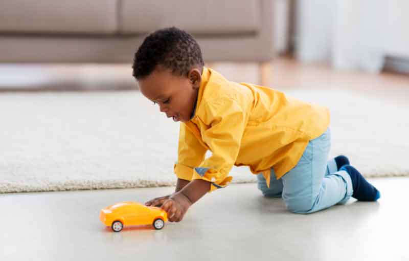 1-year-old playing with a toy car