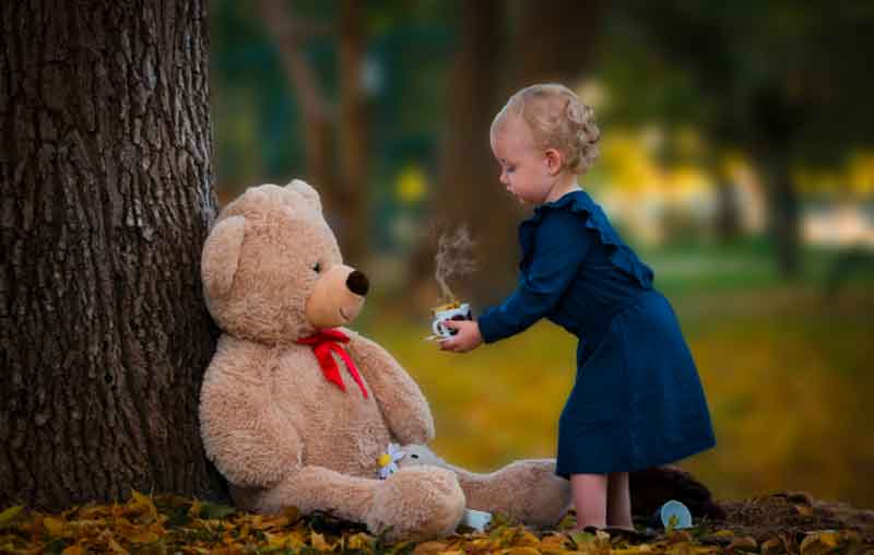 Small child playing with teddy bear