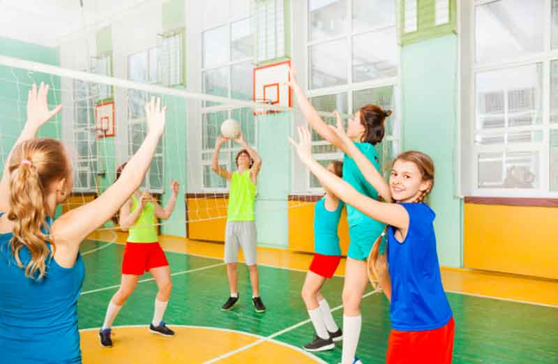 Teenagers playing volleyball