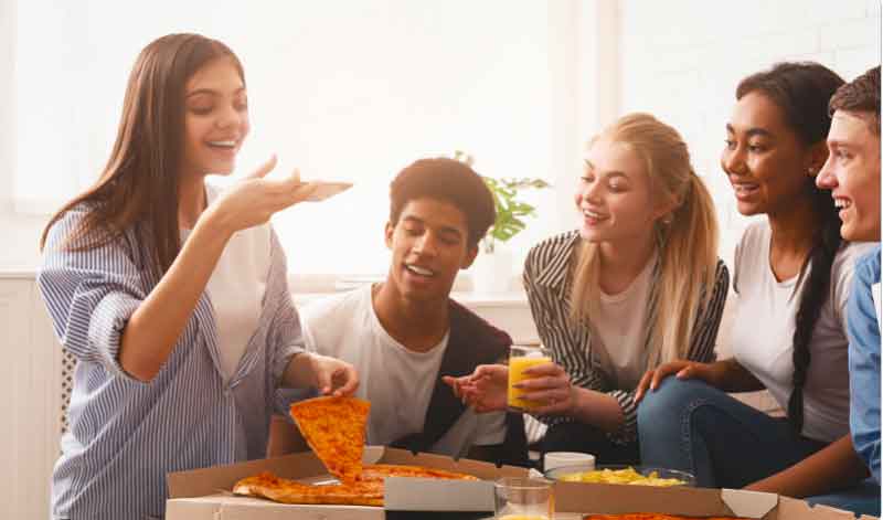 Teens taking photos of pizza